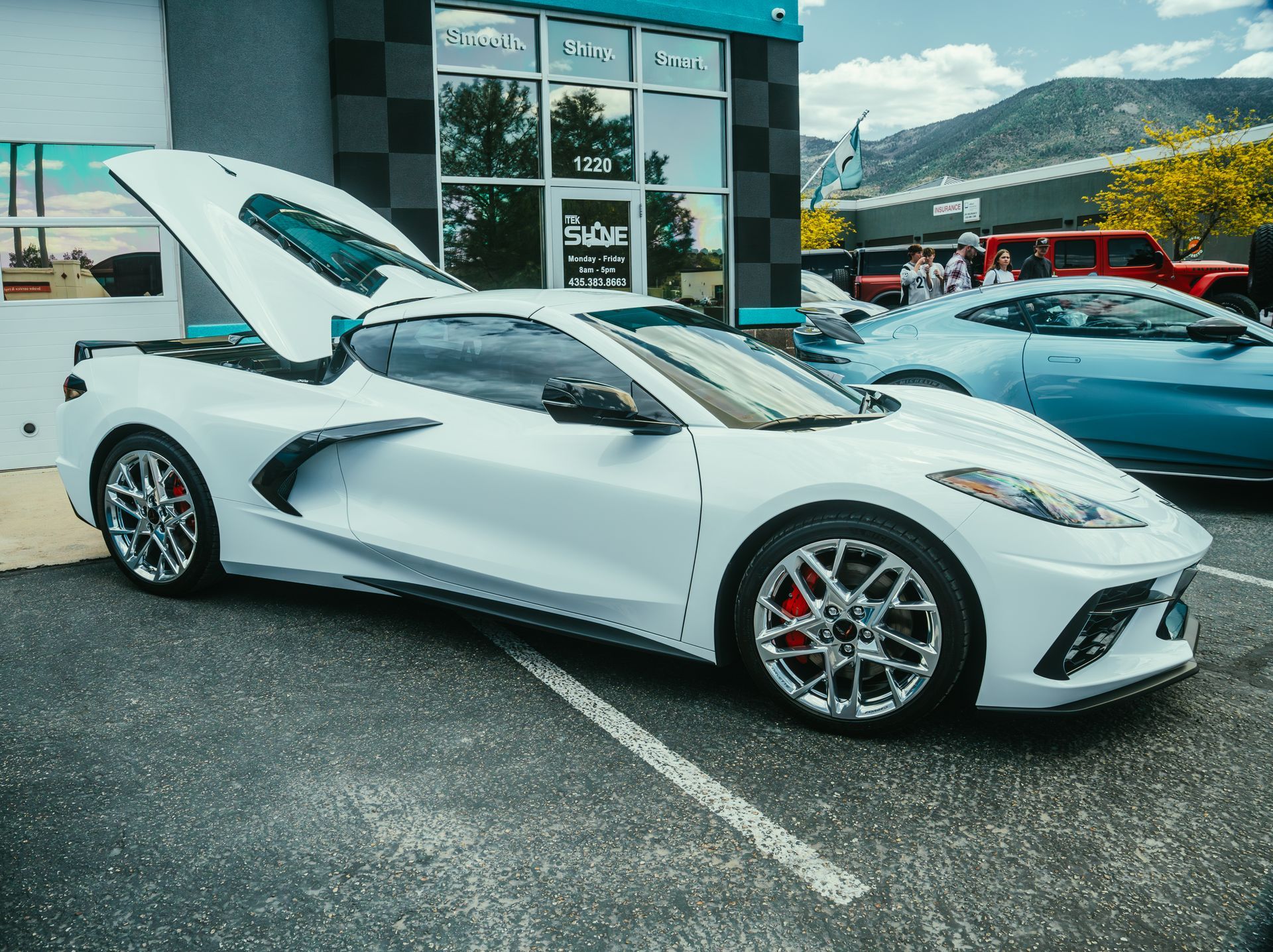a blue sports car is parked in front of a building .