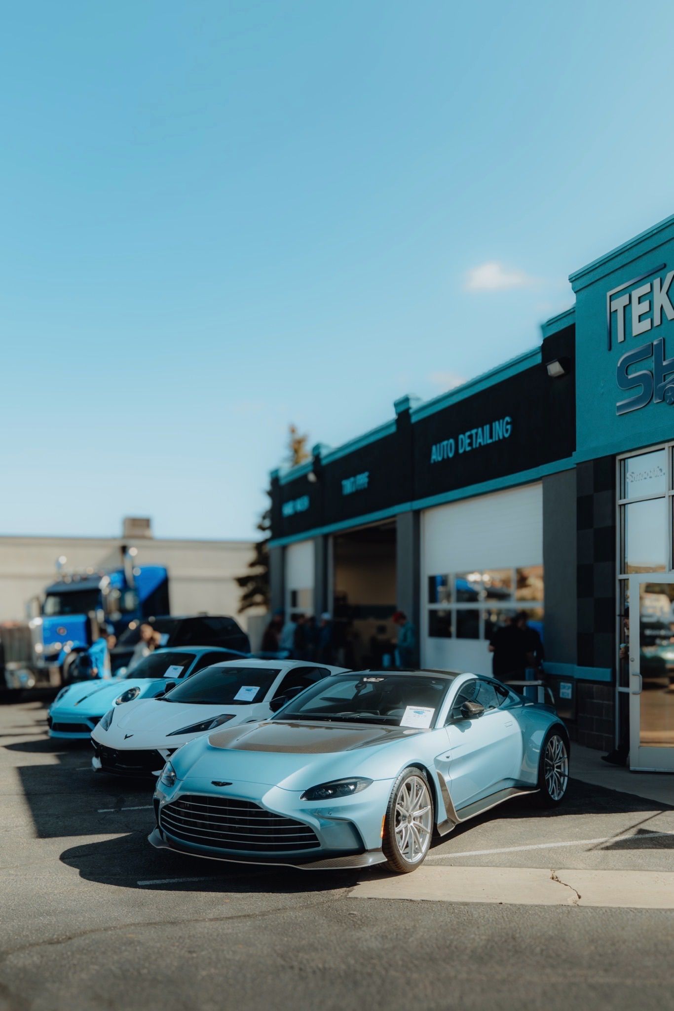 a blue porsche 911 gt3 is parked in front of a building .