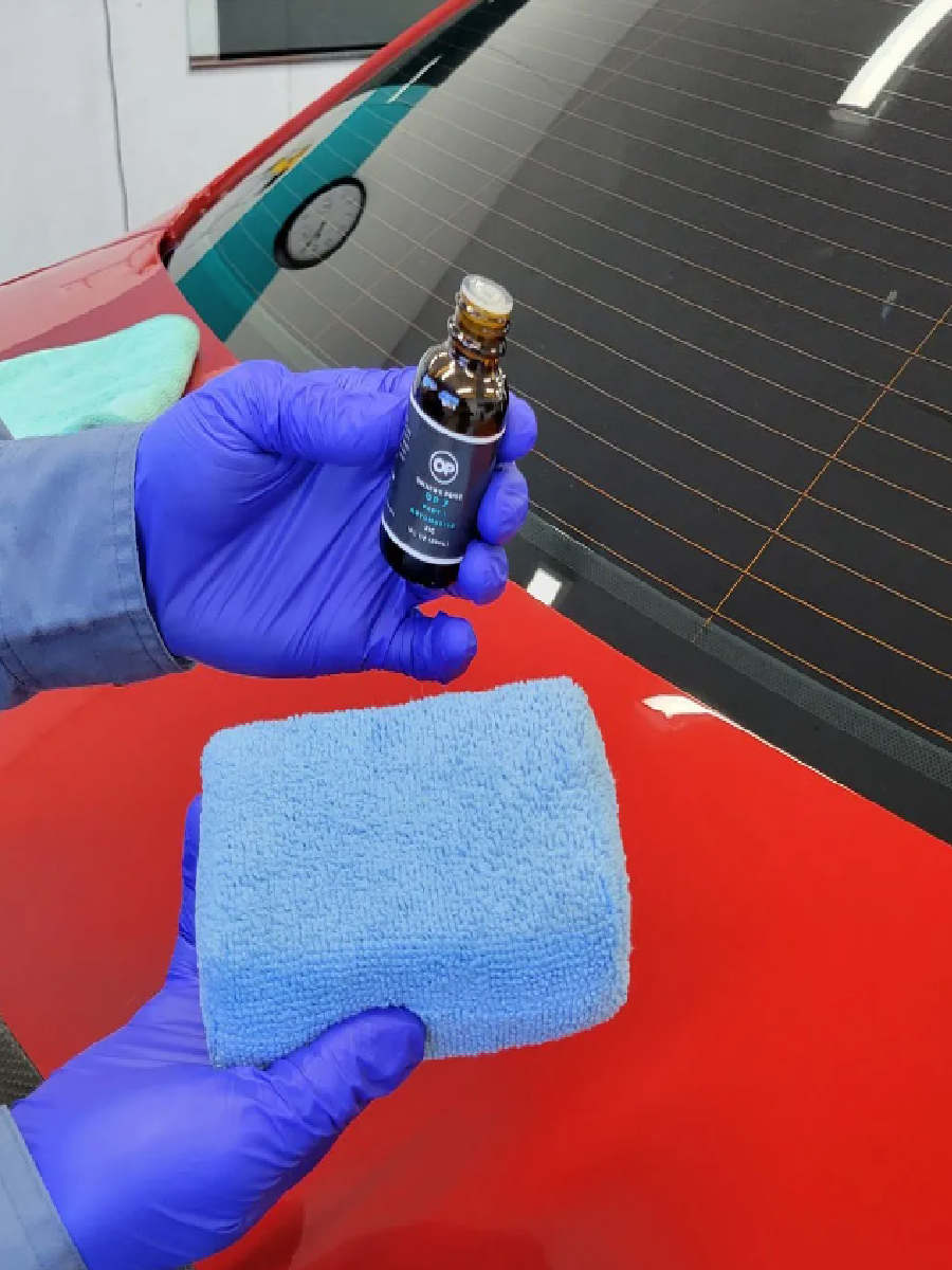 Holding ceramic coating product and towel before application.