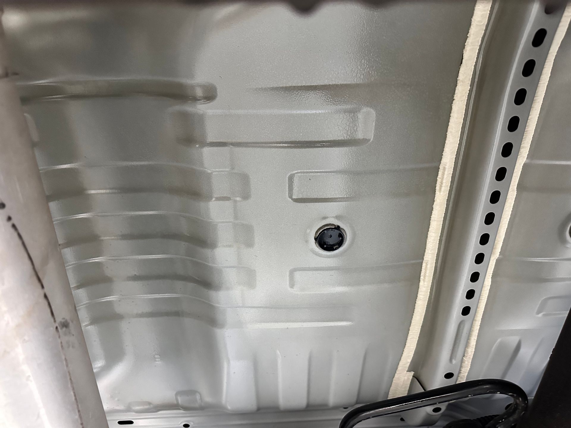 A close up of the bottom of a white car.