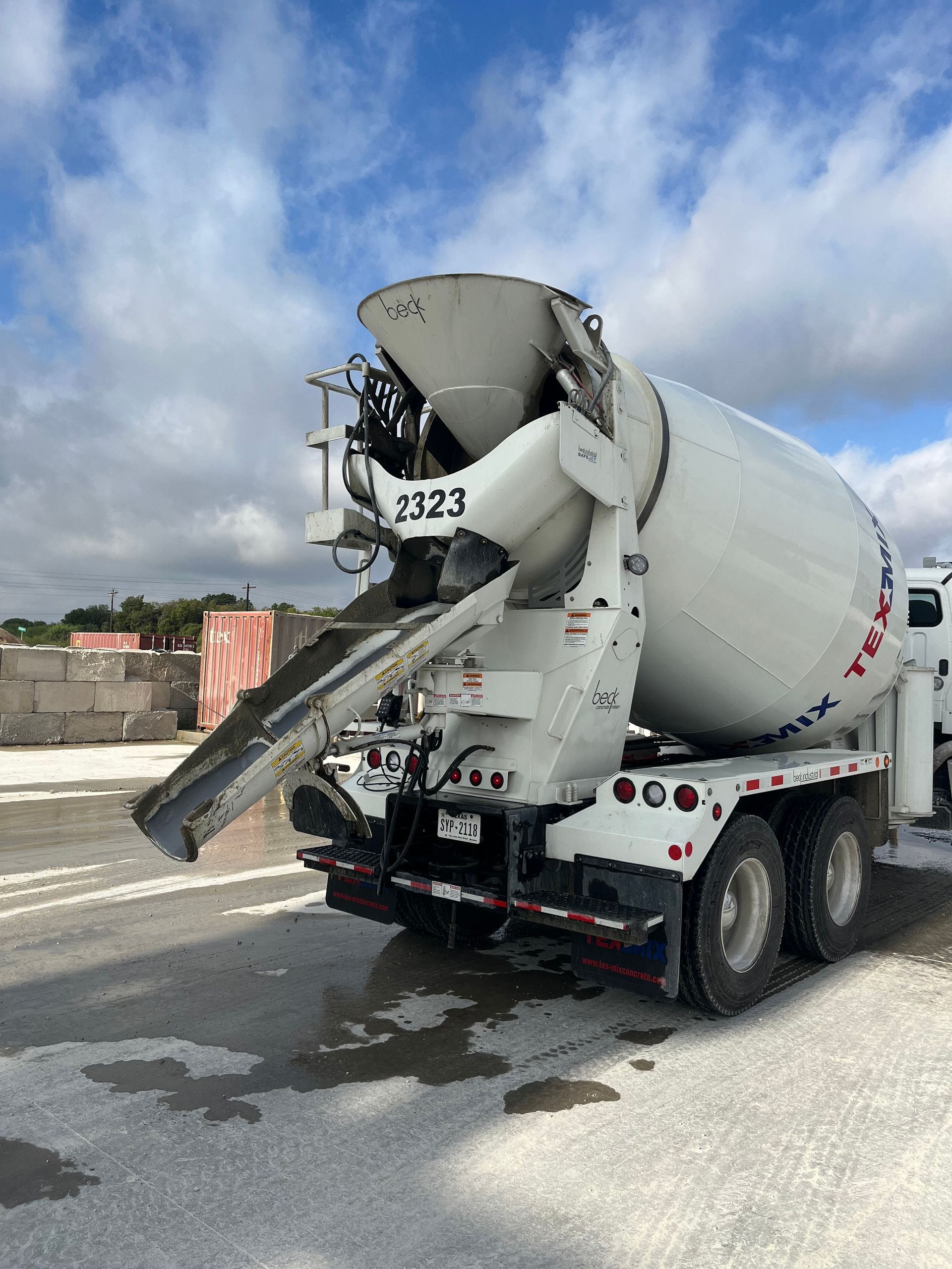 A concrete mixer truck is parked on the side of the road