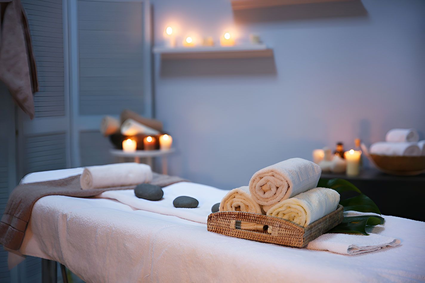 A Massage Table With Towels And Rocks On It In A Spa — Beauty Abode in Buderim, QLD