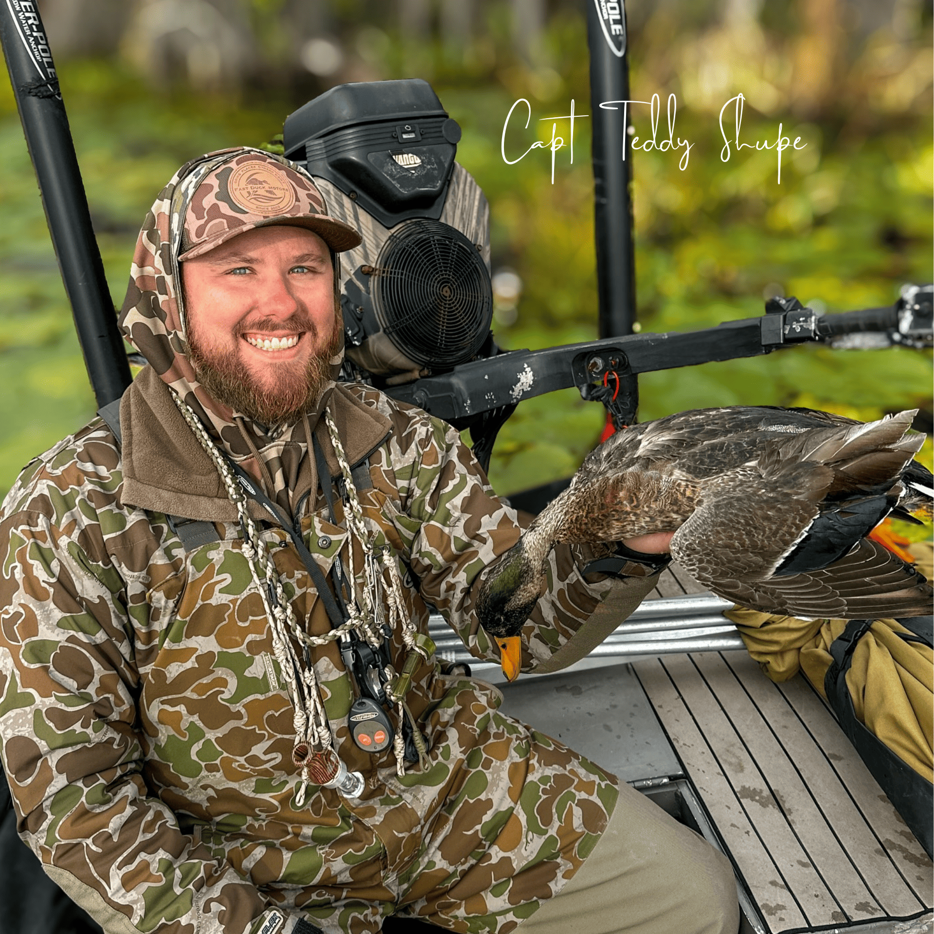 A man in a camouflage jacket is holding a duck in his hands.