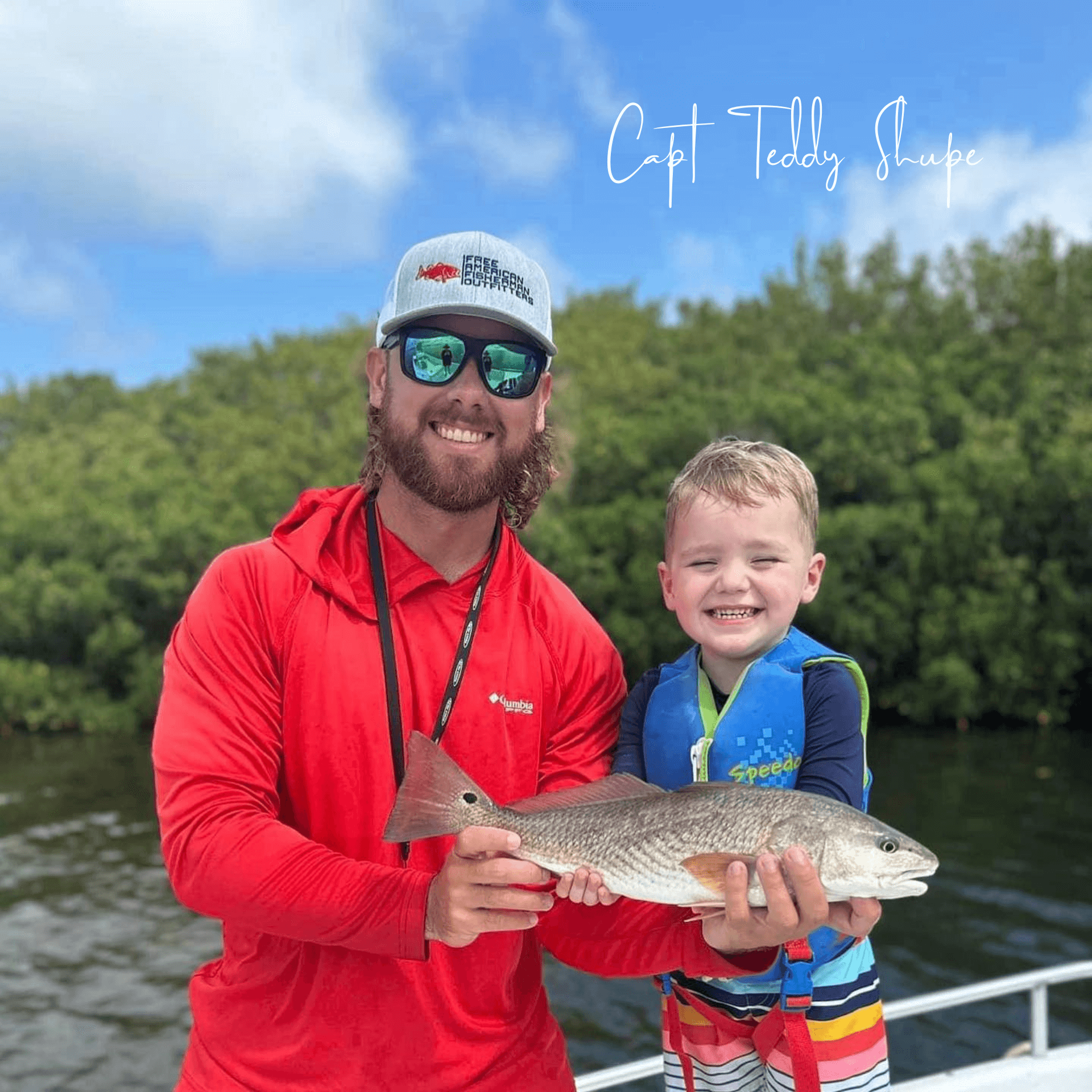 A man and a boy are holding a fish on a boat.