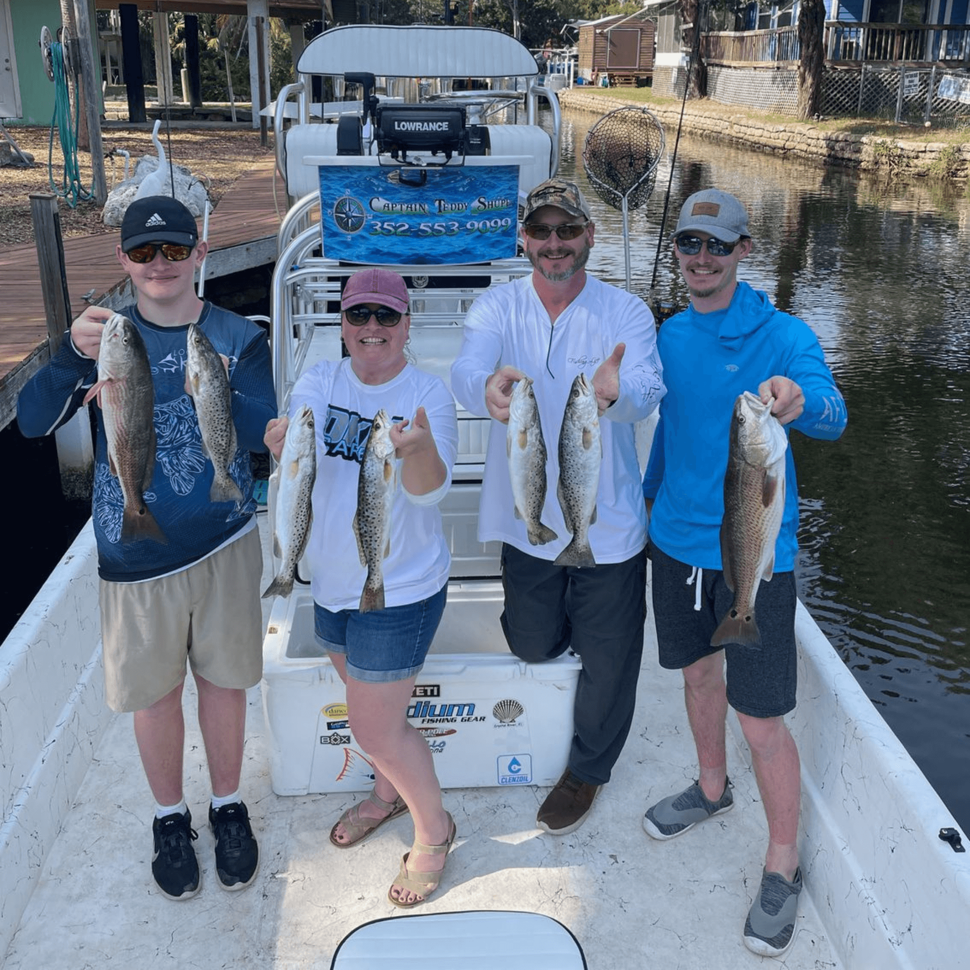 A group of people standing on a boat holding fish