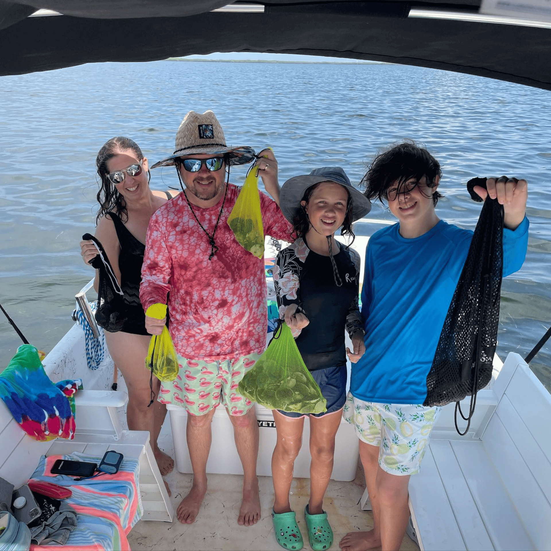 A group of people standing on a boat holding bags of crystal river scallops