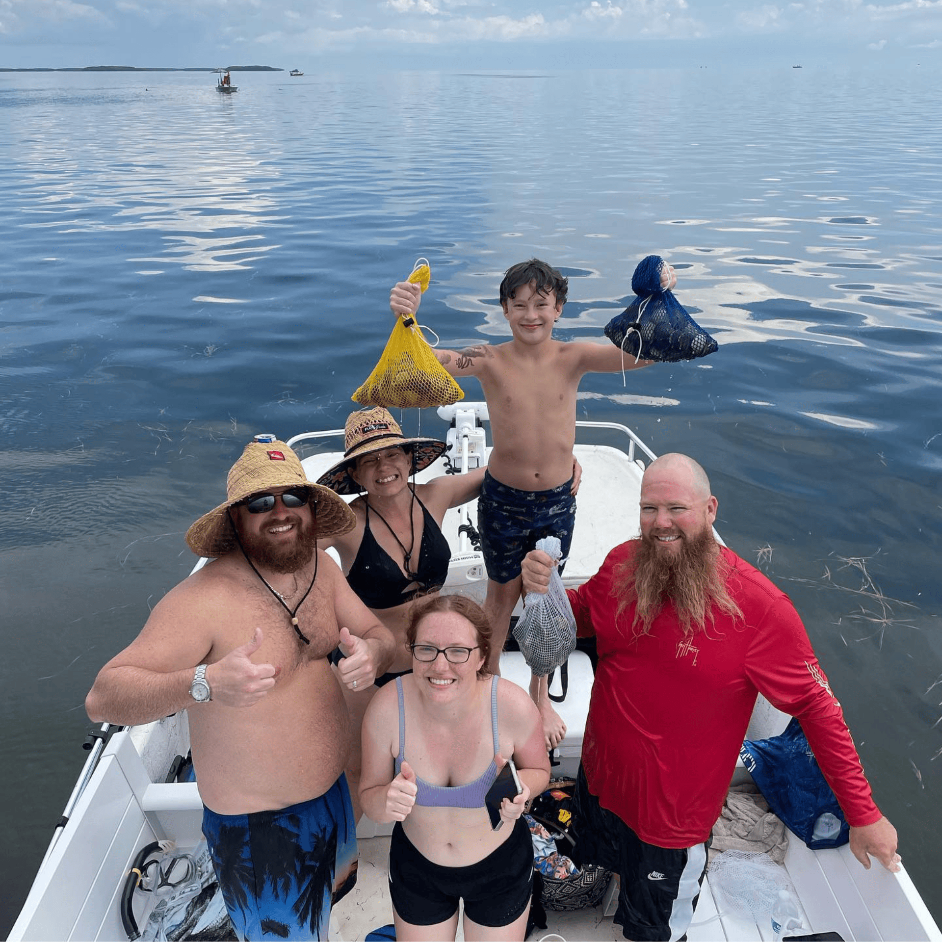 A group of people are standing on a boat in homosassa with scallop harvest