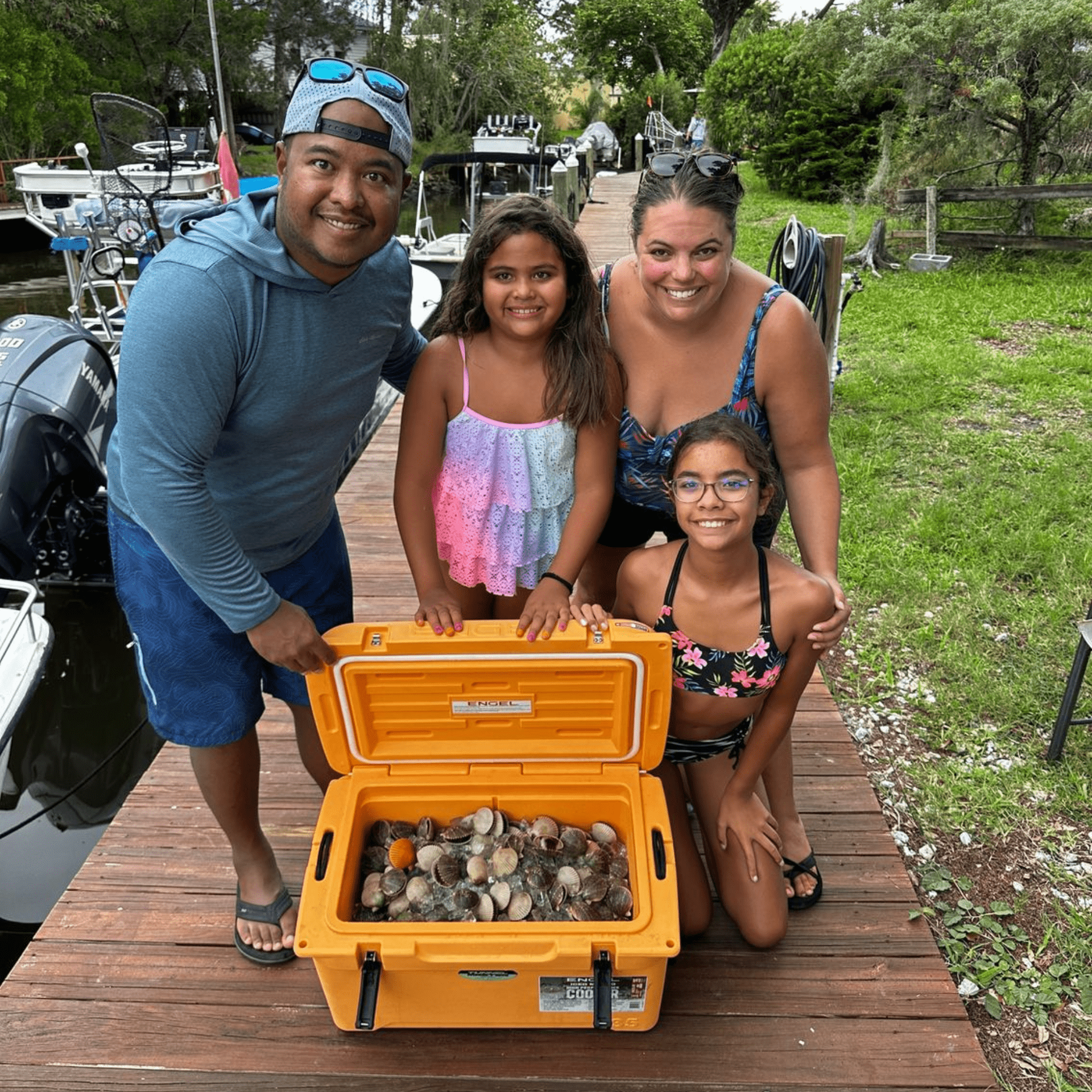 A family is posing for a picture next to a yellow cooler filled with rocks.