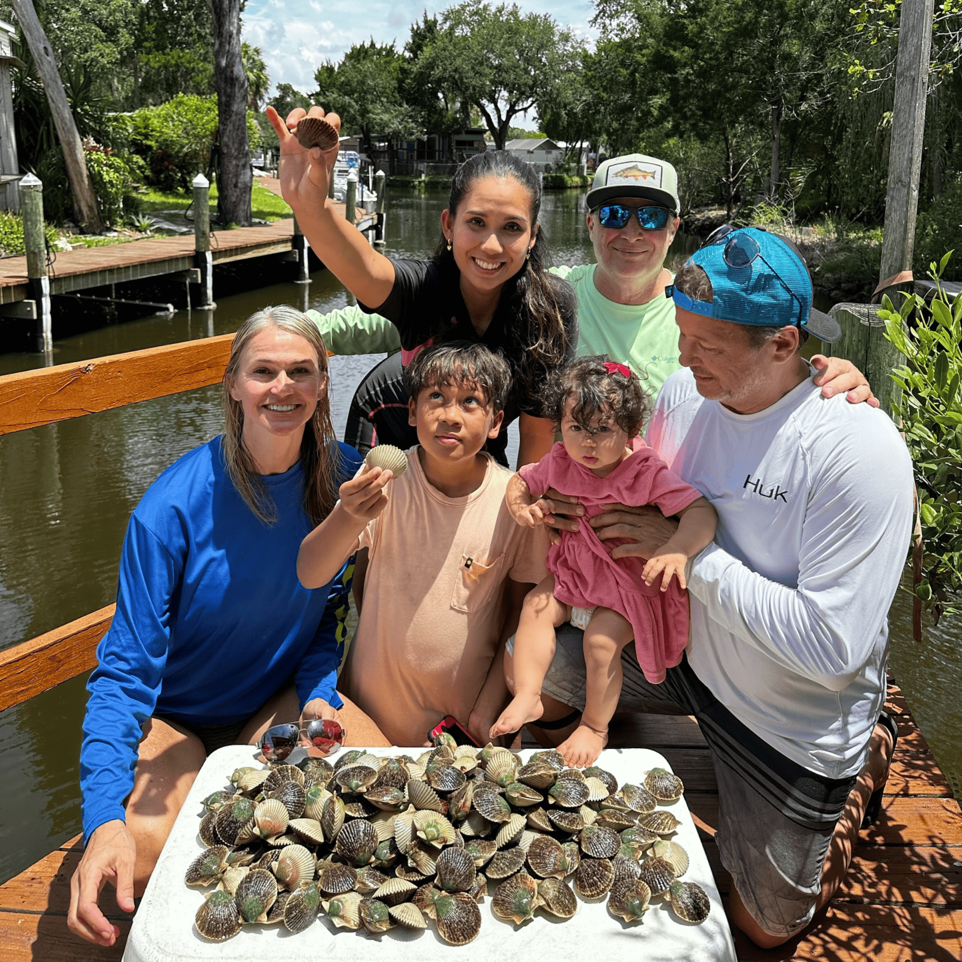 A group of people standing around a table with scallops on it.