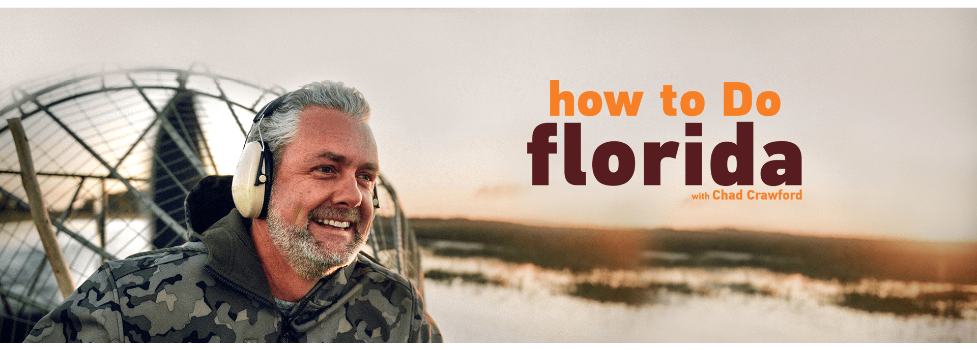 A man wearing headphones is sitting in an airboat.