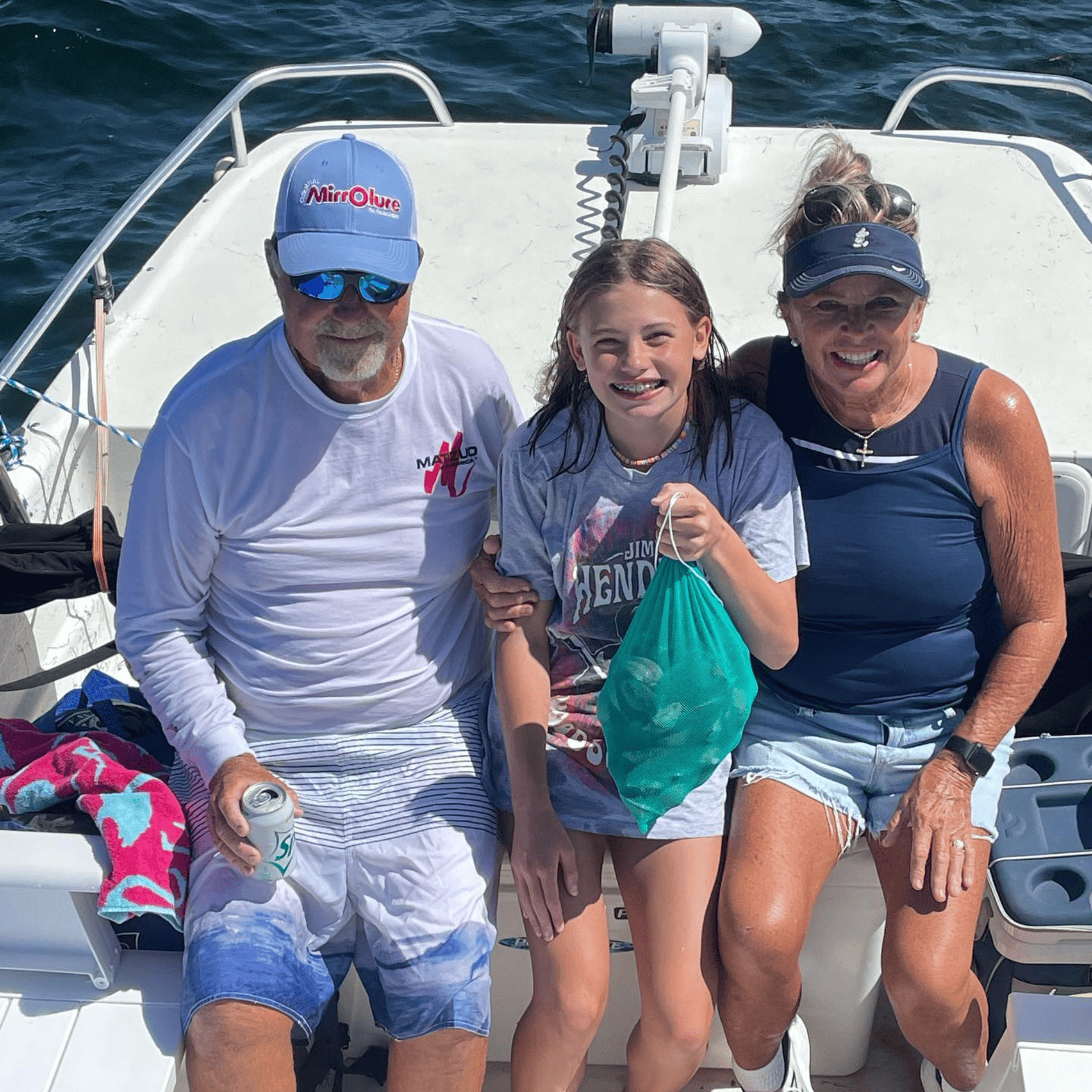 A man and two women are posing for a picture on a boat.