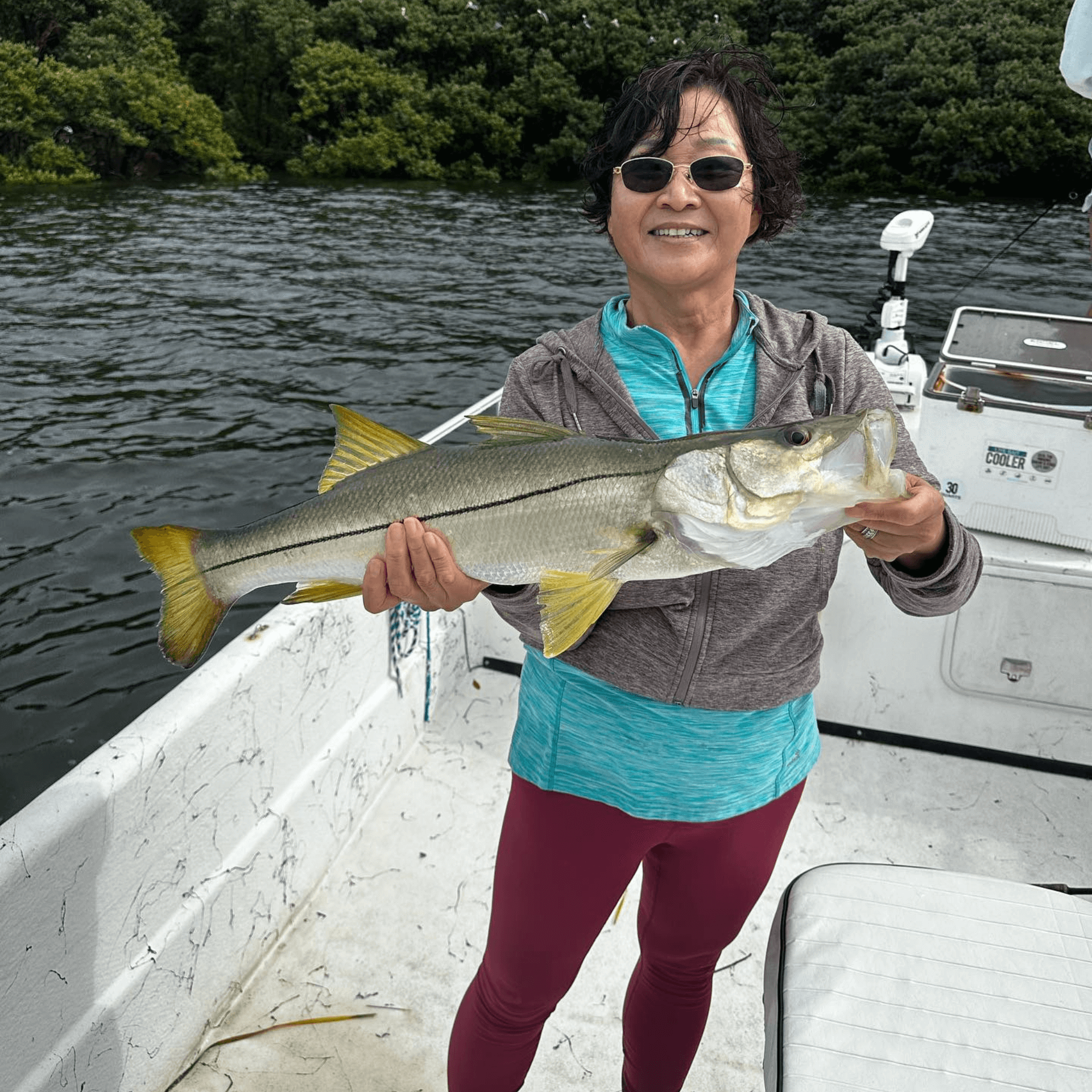 A woman is holding a large Snook caught in Crystal River with Capt Teddy Shupe