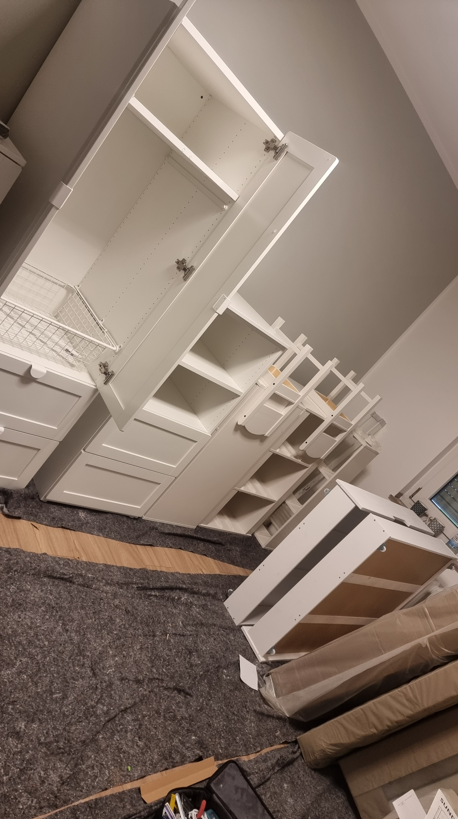 Weiße Schranktüren und Regale an verschiedenen Positionen im Innenbereich.