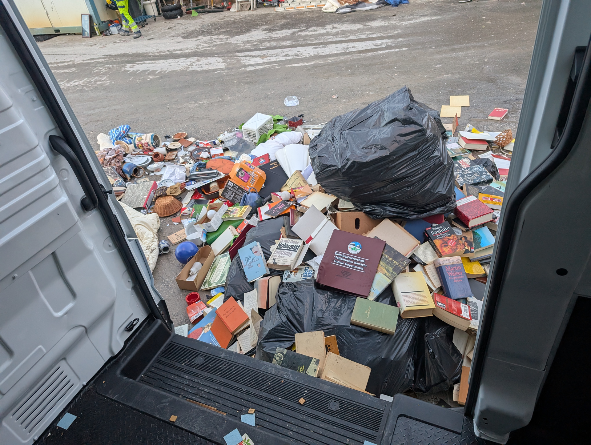 Im Inneren eines Lastwagens, überfüllt mit Müll und Büchern, wahrscheinlich eine Müllhalde.