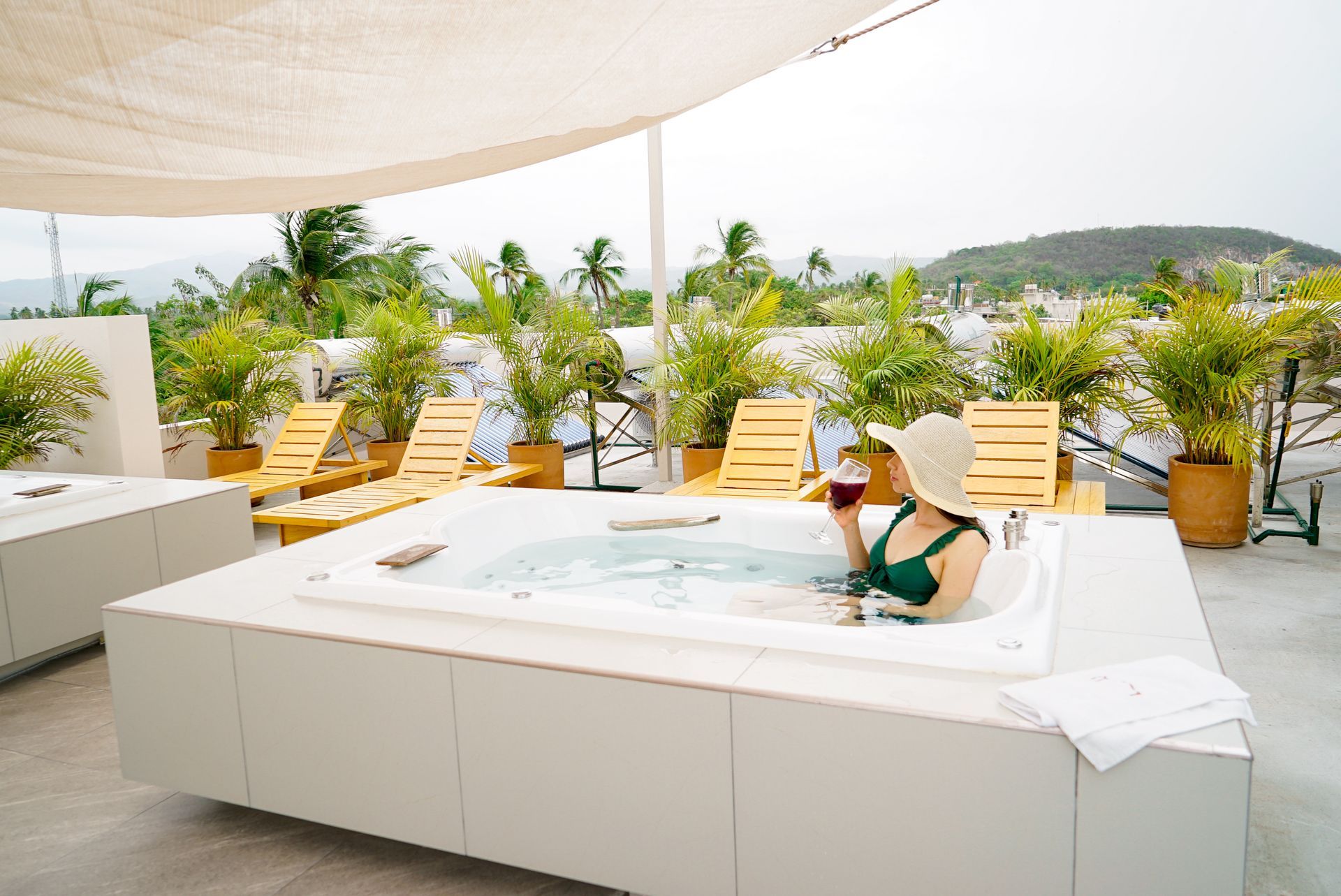 Una mujer en un jacuzzi con una copa de vino.