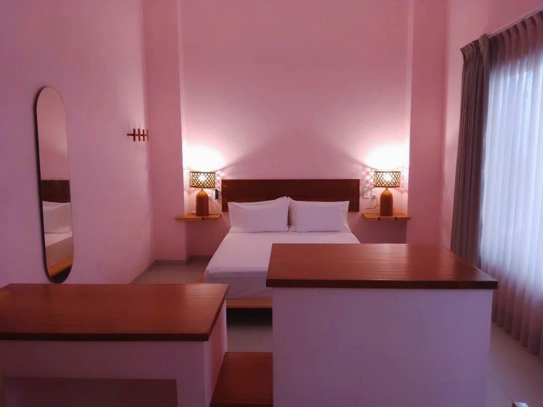 Un dormitorio con paredes rosas y una cama grande.