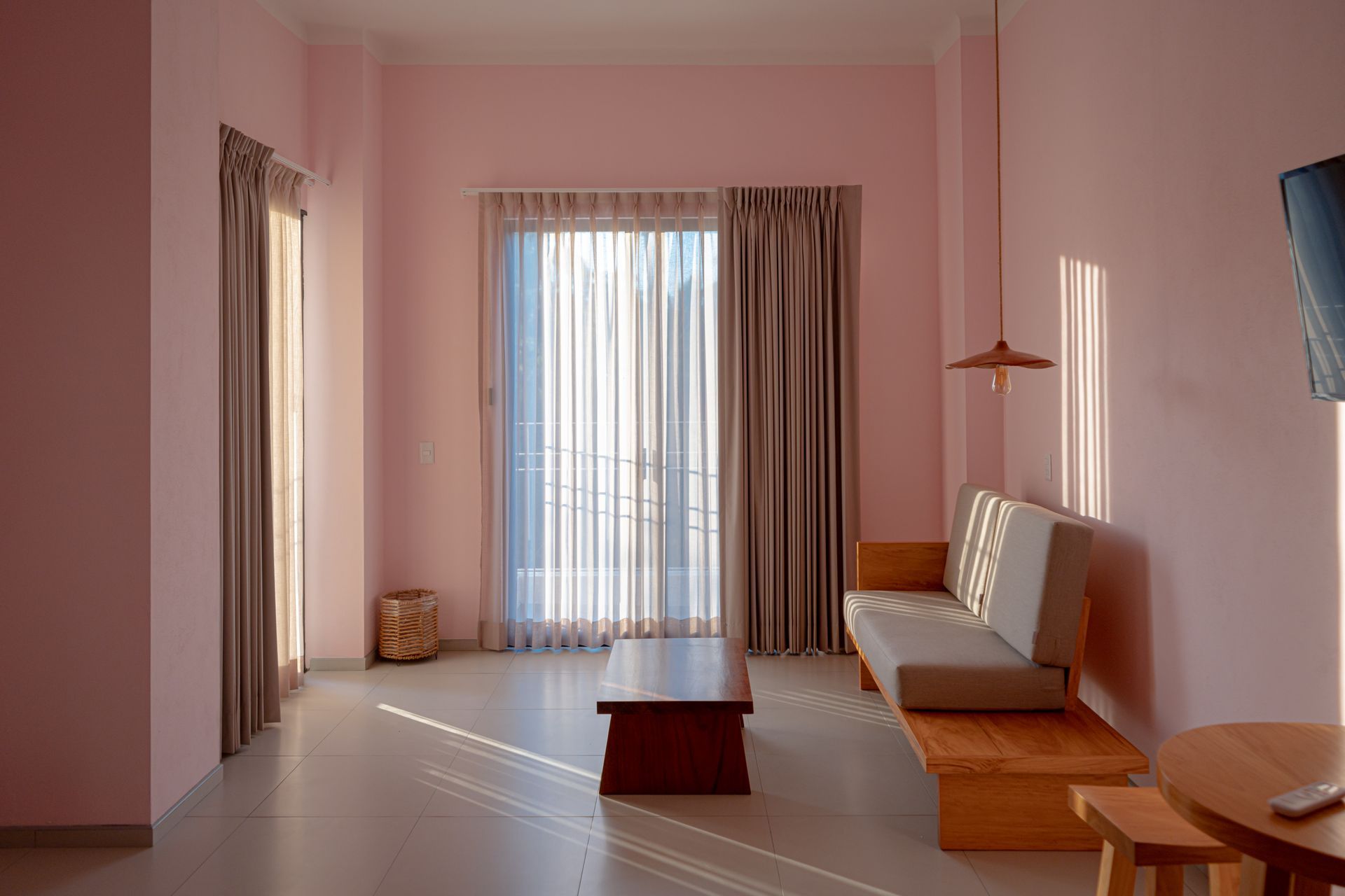 Una sala con una mesa de centro, un sillón doble y una lámpara.