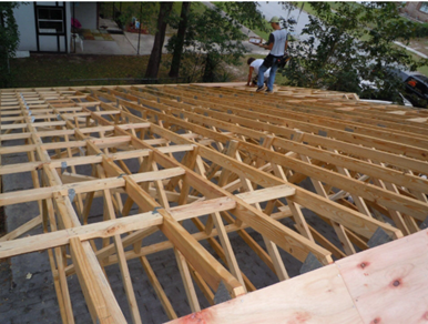 A residential roofer in Orange Park installs wooden beams on a roof, ensuring structural integrity. A residential roofer in Orange Park installs wooden beams on a roof, ensuring structural integrity.
