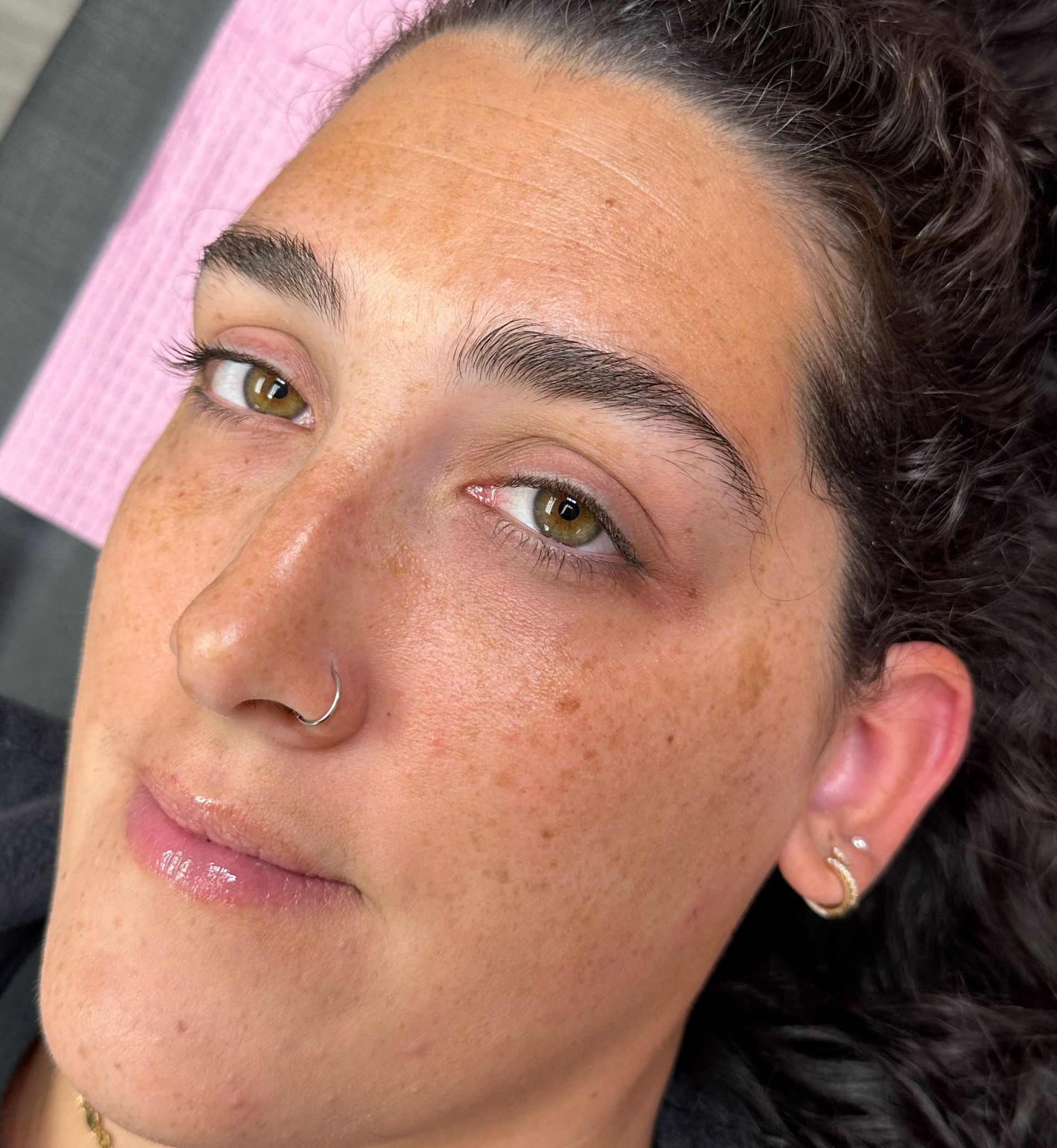 A close up of a woman 's face with a nose ring.