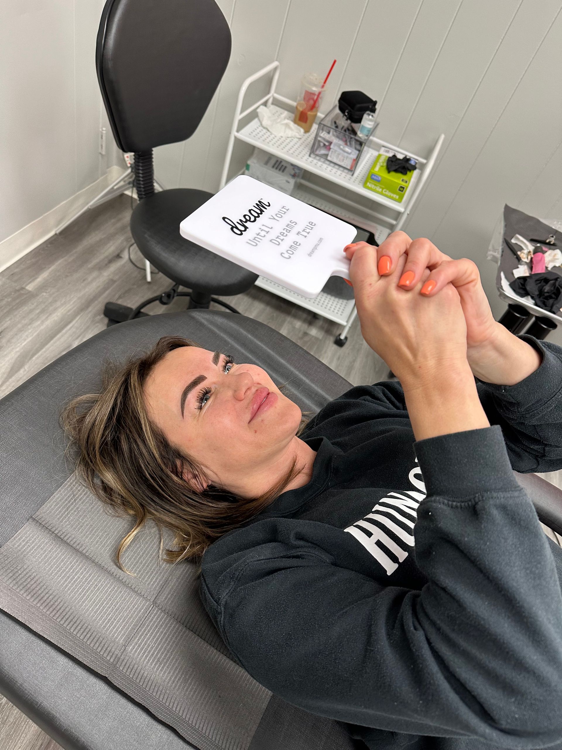 A woman is laying on a chair with her hands folded in prayer.