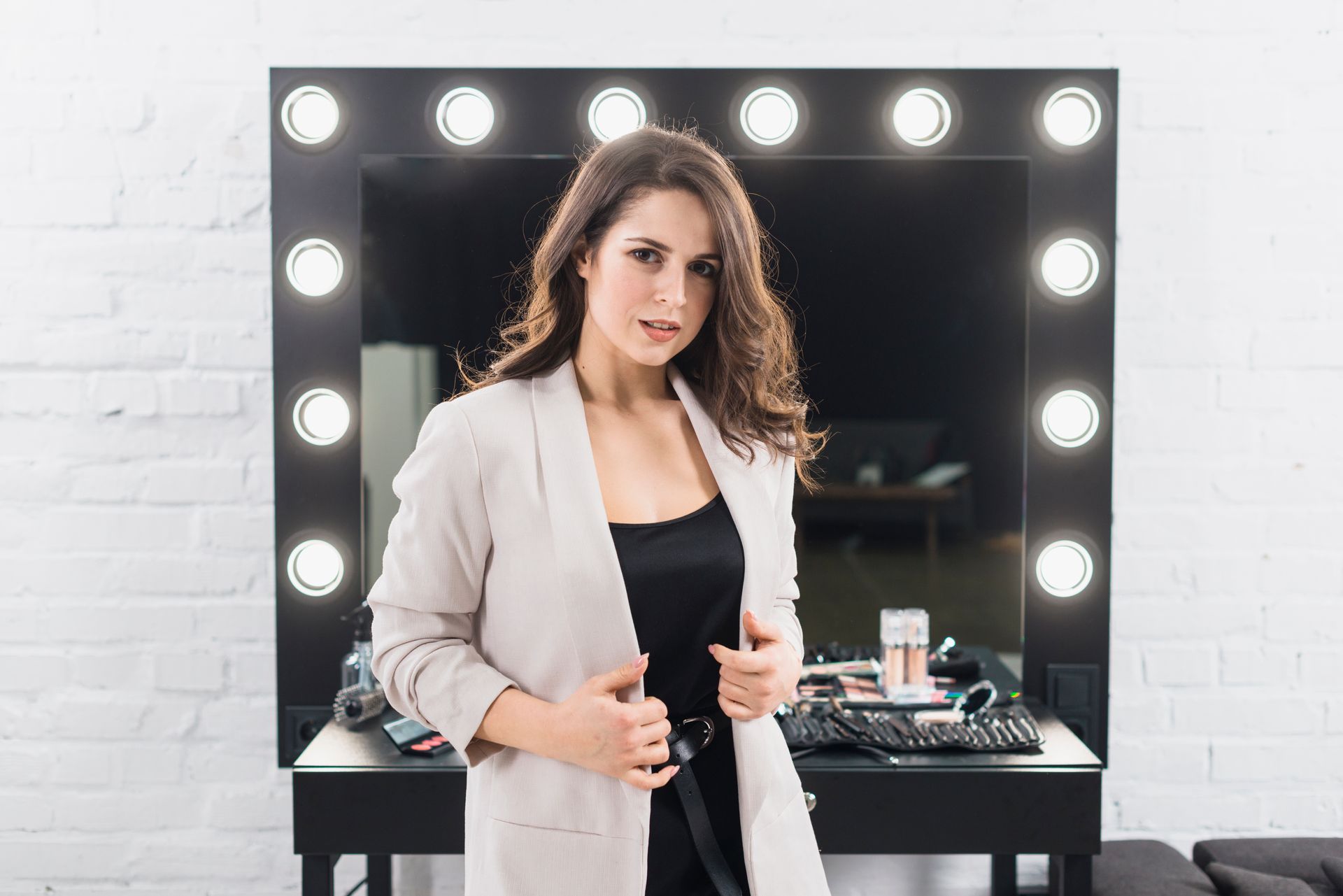 A woman is standing in front of a mirror in a room.