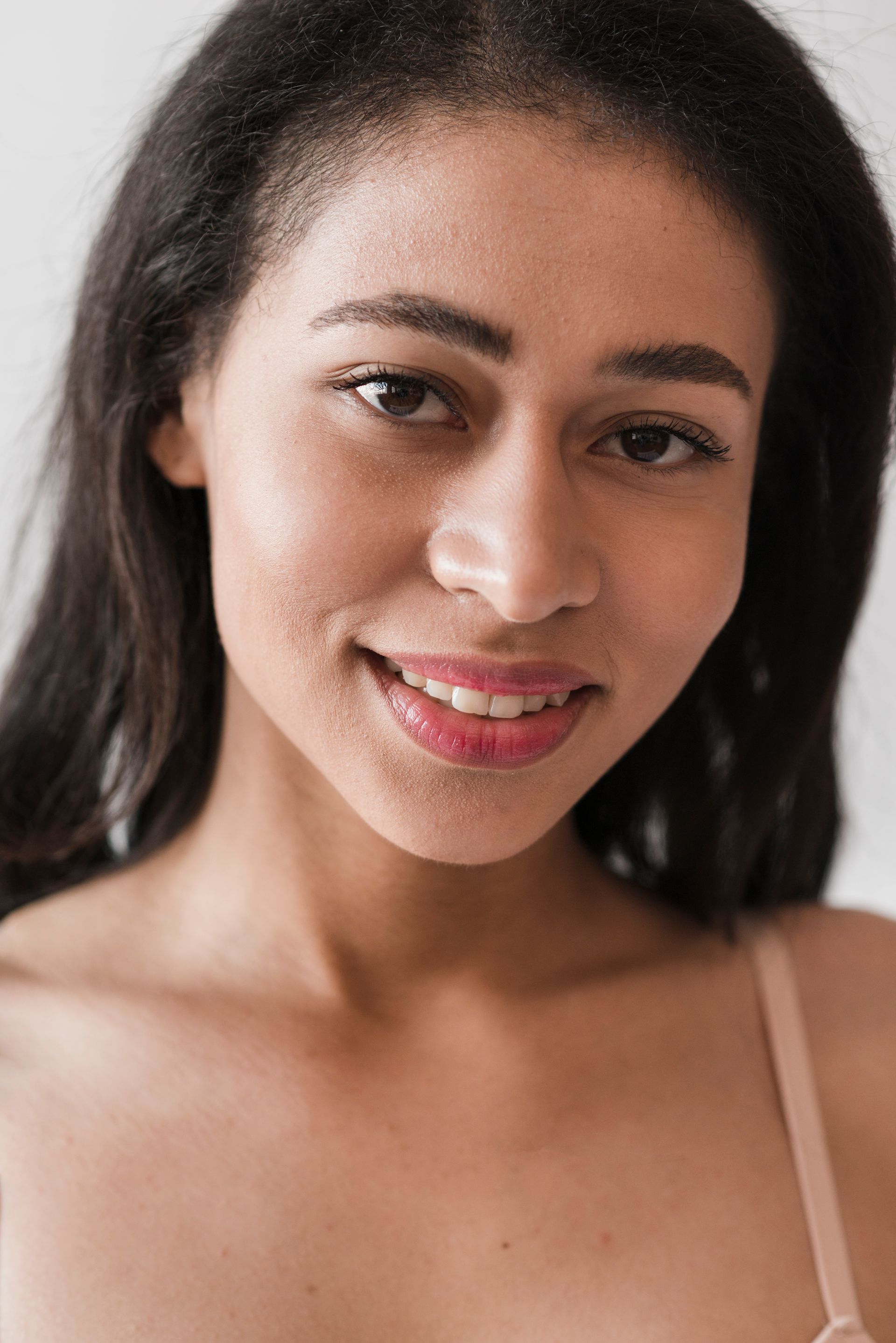 A close up of a woman in a bra smiling at the camera.