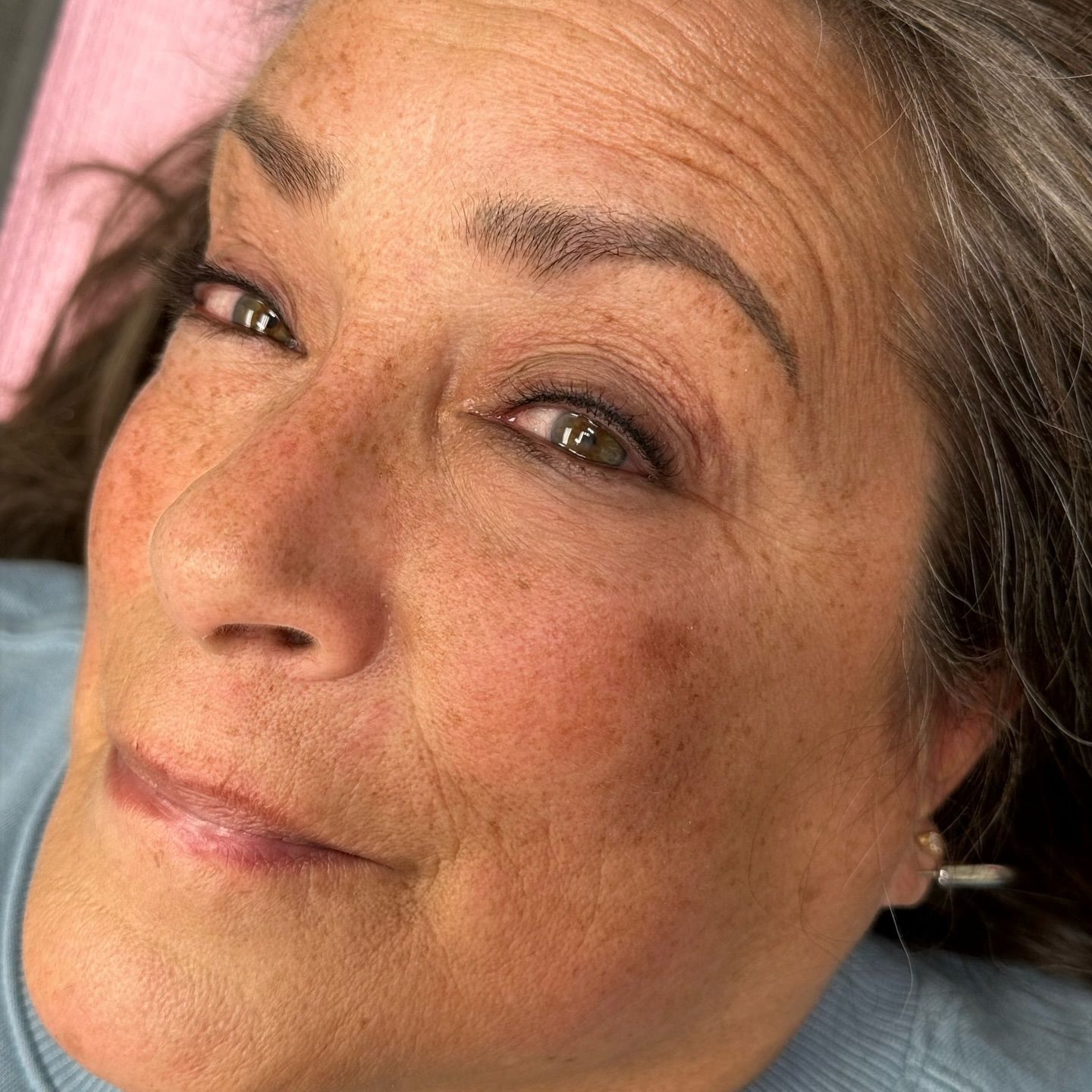 A close up of a woman 's eyes with a brown background.