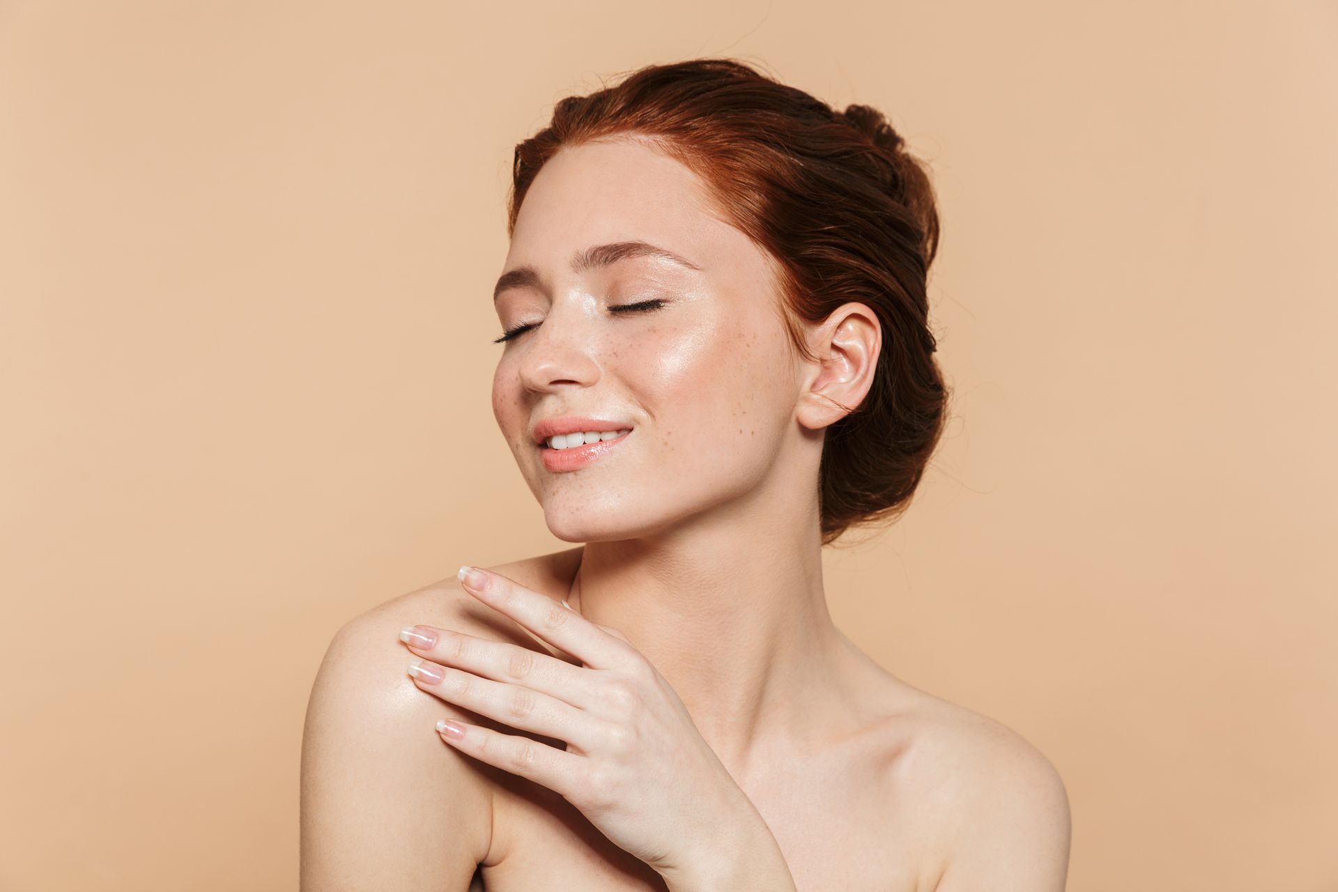 A close up of a woman 's face with her eyes closed and her hand on her shoulder.