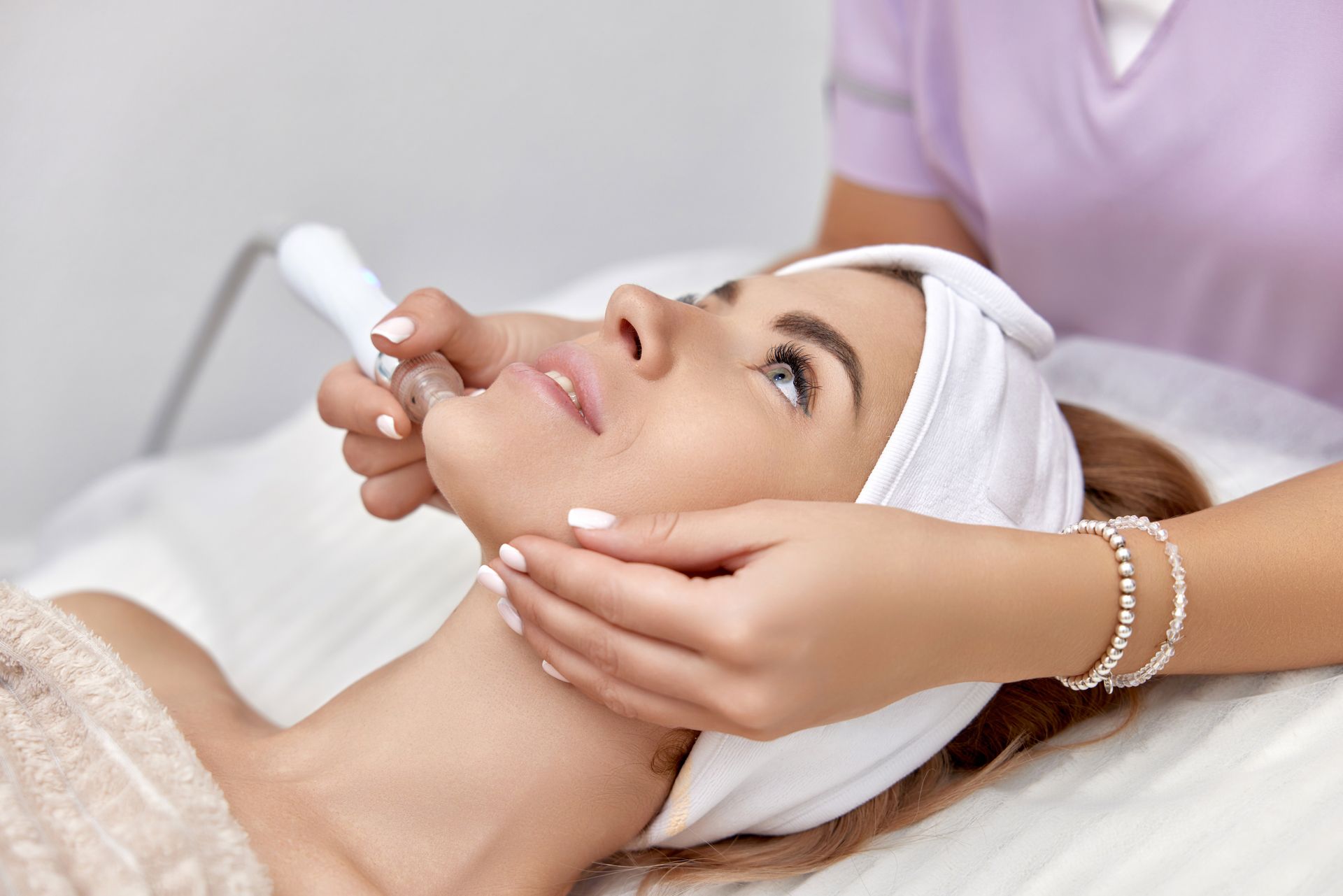 A woman is getting a facial treatment at a beauty salon.