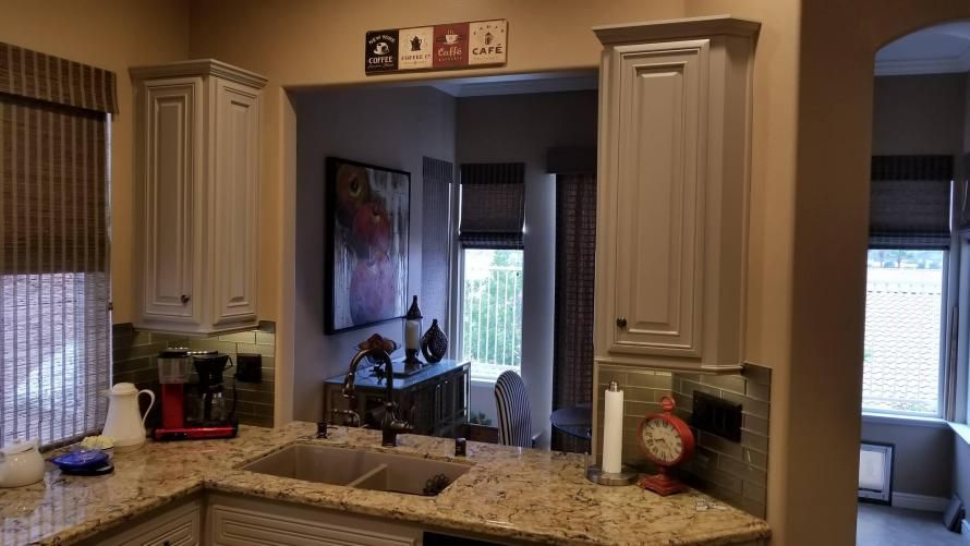 A kitchen with a sink , cabinets , and granite counter tops.