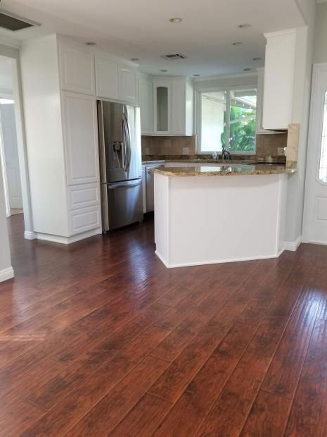 A kitchen with hardwood floors and stainless steel appliances