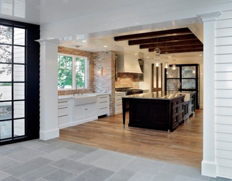 A kitchen with white cabinets and a black island