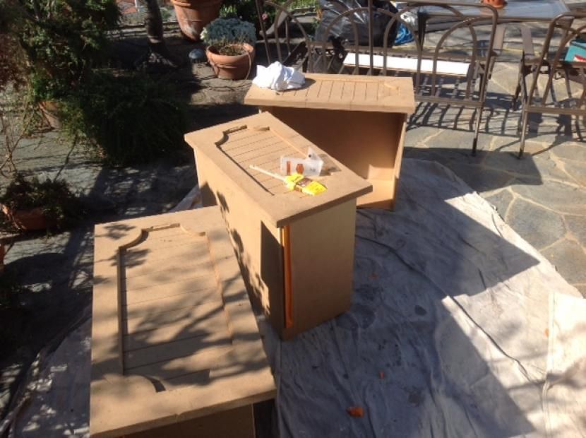 Two cardboard boxes are sitting on a stone patio