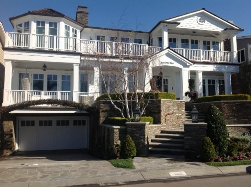 A large white house with a garage and stairs