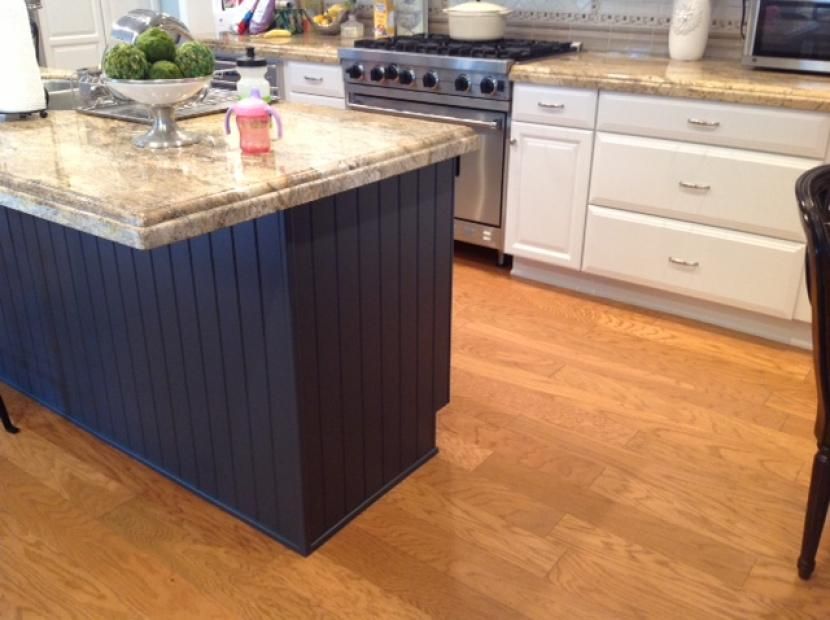 A kitchen with a blue island and white cabinets