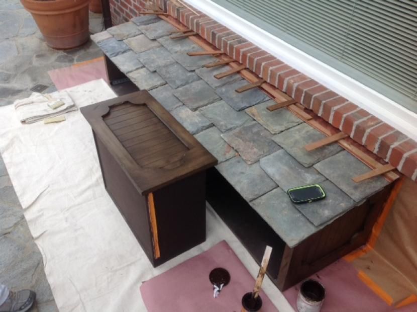 A wooden box is sitting on a table next to a brick wall