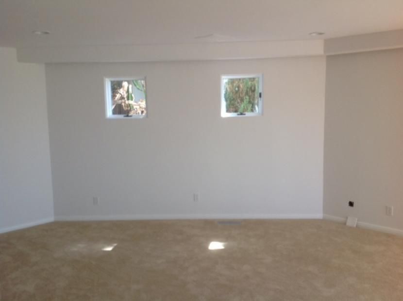 An empty room with two windows on the wall