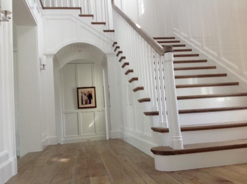 A hallway with stairs and a picture on the wall