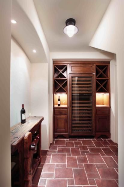 A bottle of wine sits on a table in a wine cellar