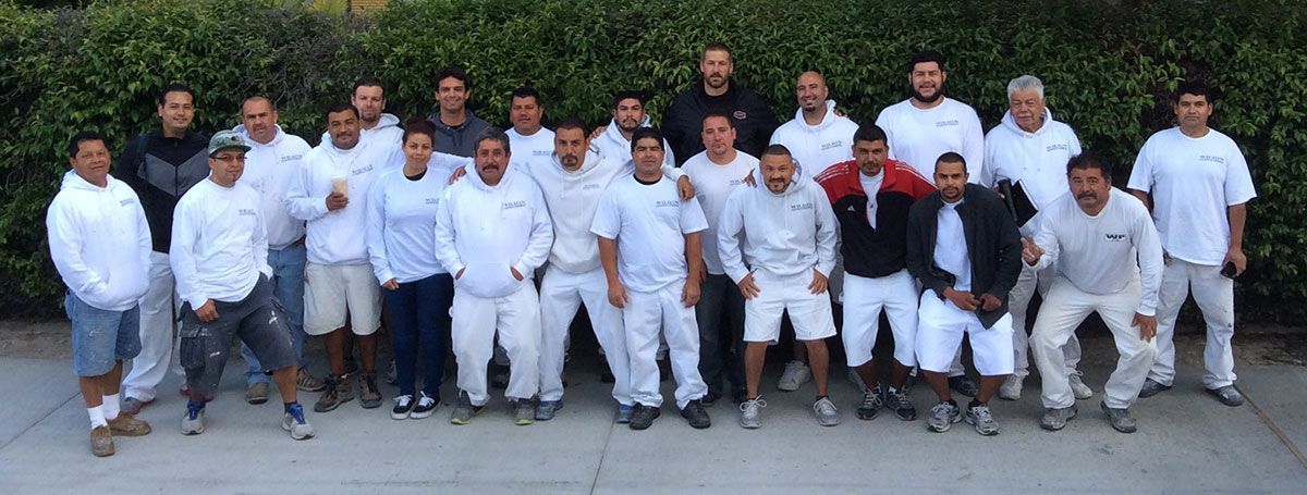 A group of men in white shirts and shorts are posing for a picture.