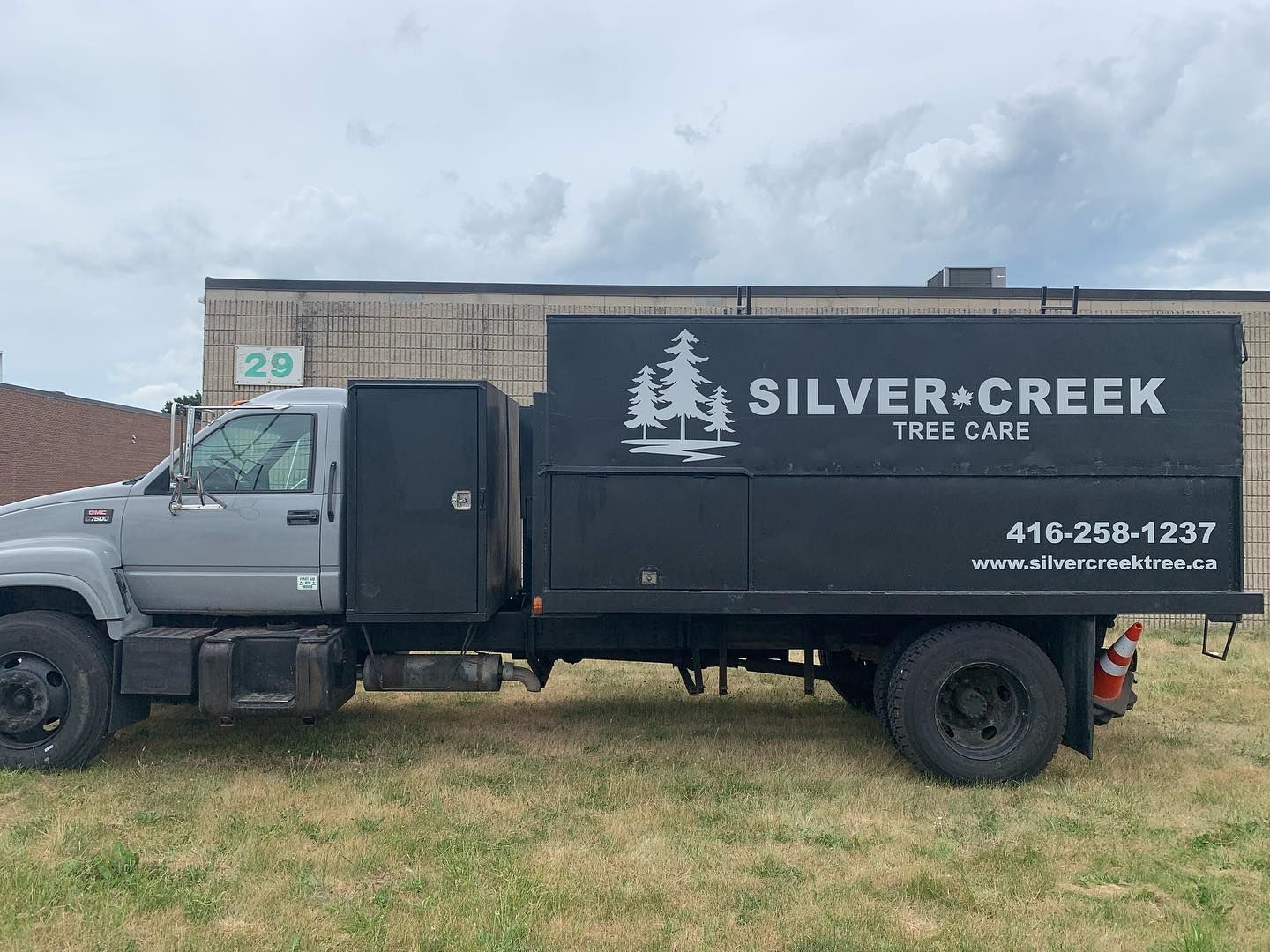 silver creek tree care truck parked in front of a building.