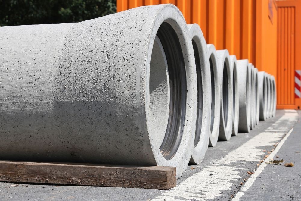 Concrete Pipes Lined up On a Wooden Beam — Cessnock Landscaping Supplies In Cessnock, NSW