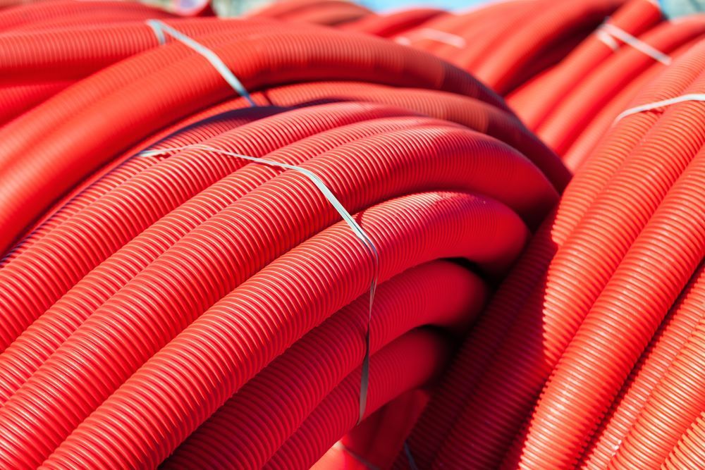 Red Corrugated Plastic Tubing Bundled Together — Cessnock Landscaping Supplies In Maitland, NSW