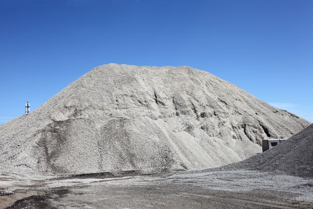 Large Gray Gravel Pile Under a Clear Blue Sky — Cessnock Landscaping Supplies In North Rothbury, NSW