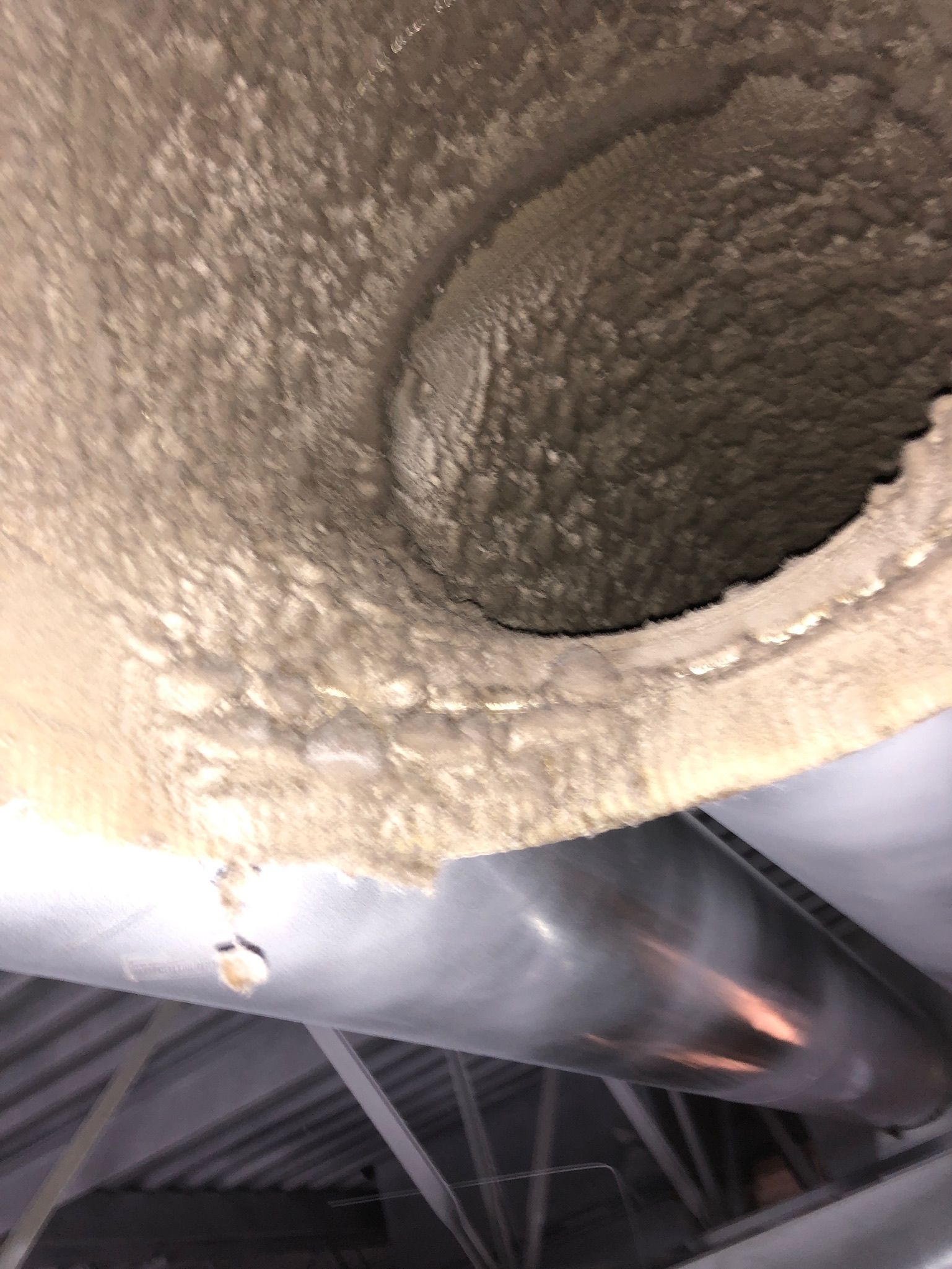 A close up of a dirty exhaust pipe in a building.