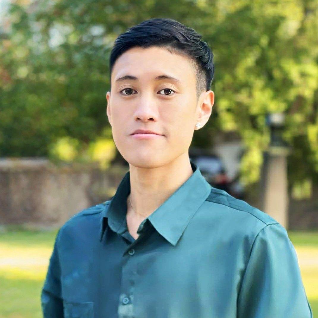 A young man wearing a black shirt and a gold chain