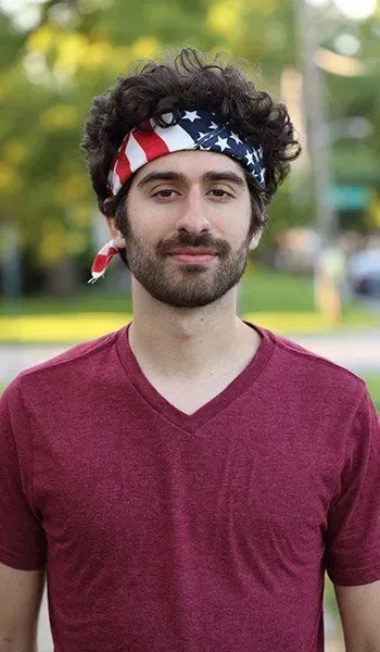 A man with a beard wearing an american flag bandana on his head.