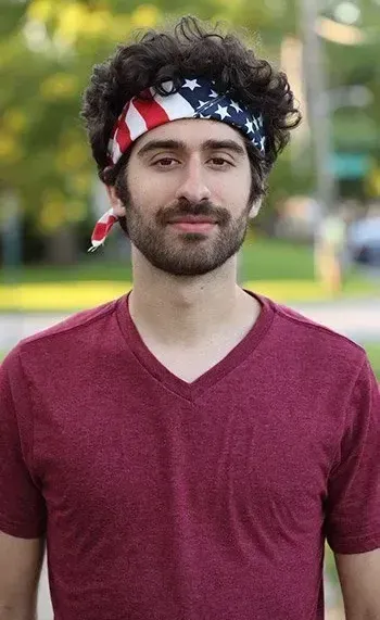 A man with a beard wearing an american flag bandana on his head.
