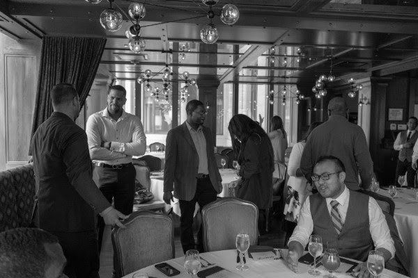 A group of people are sitting at tables in a restaurant.