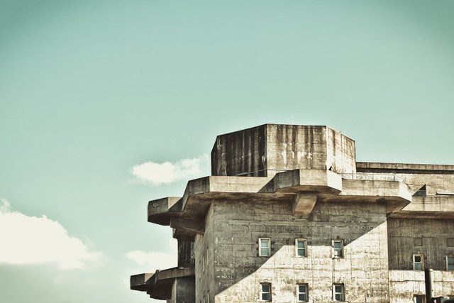 A large concrete building with a blue sky in the background.